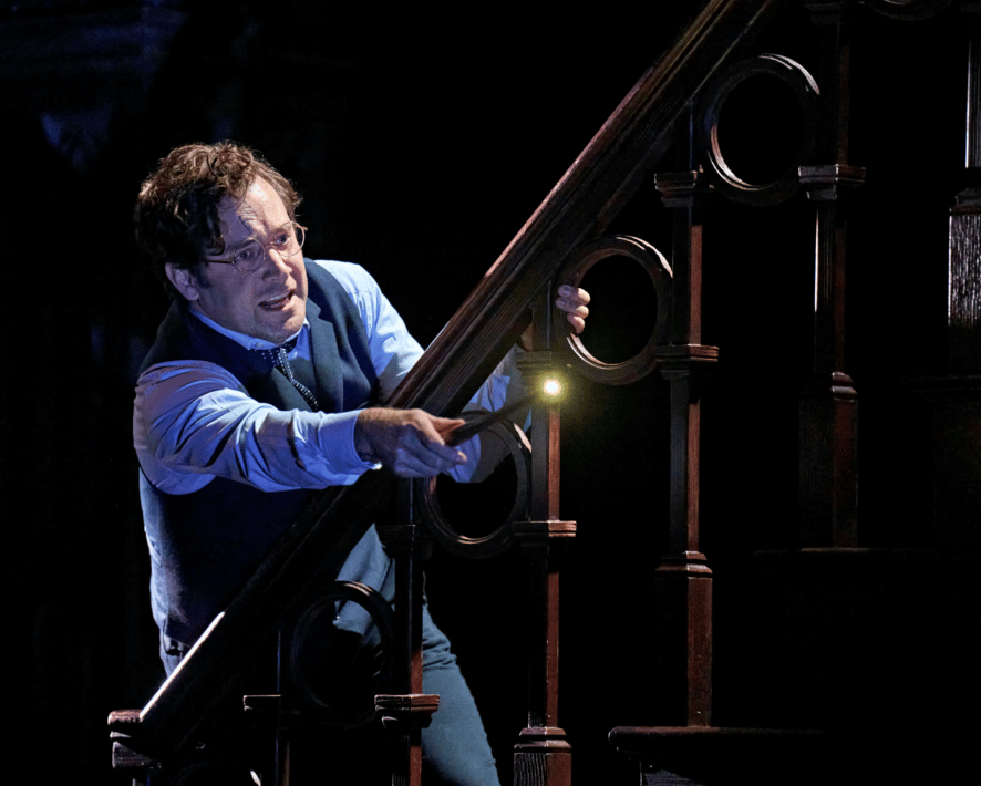 Harry Potter, played by Sam Crane, points his wand over a staircase.
